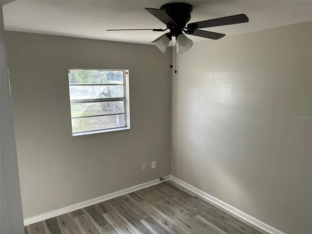 an empty room with a window and a fan