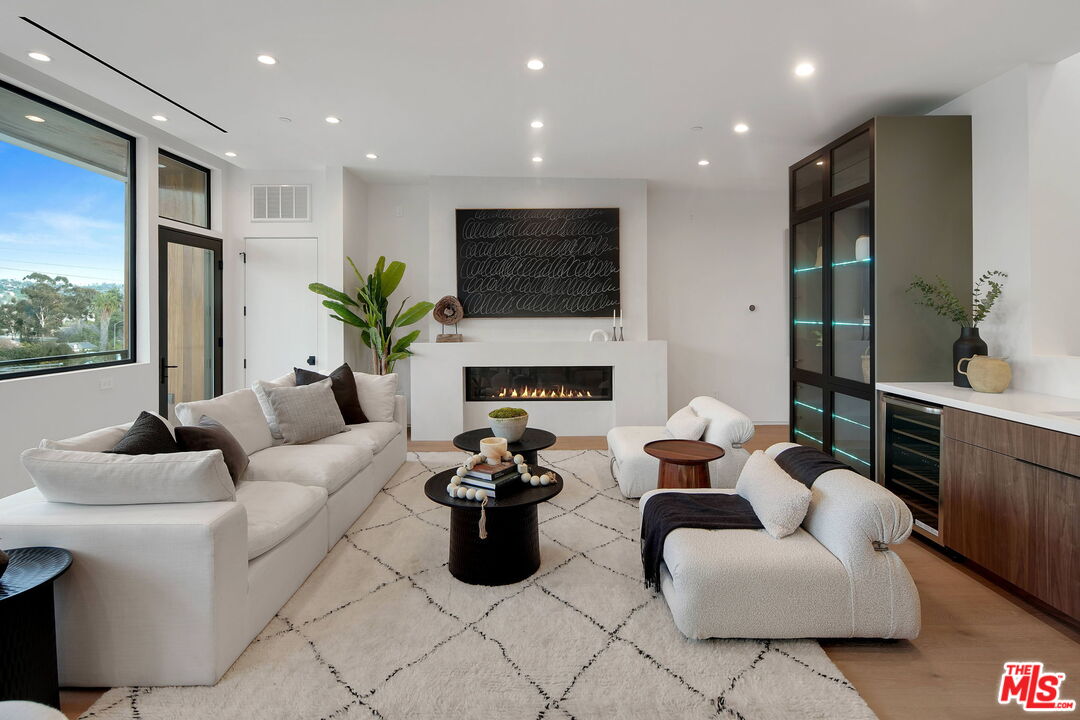 a living room with furniture fireplace and a large window