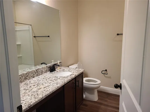 a bathroom with a granite countertop sink toilet and shower