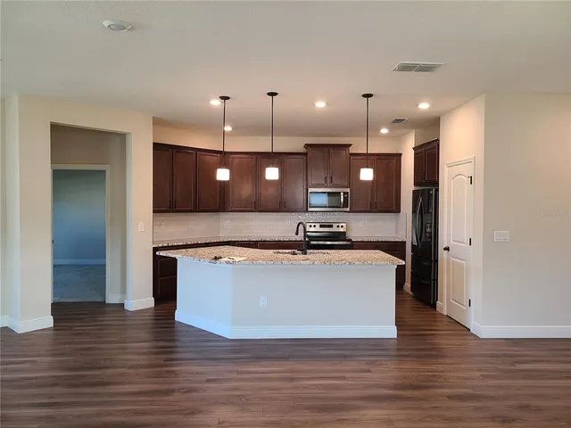 a view of kitchen with refrigerator and microwave