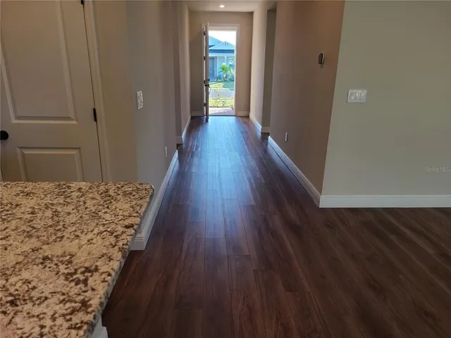 a view of a hallway with wooden floor and stairs
