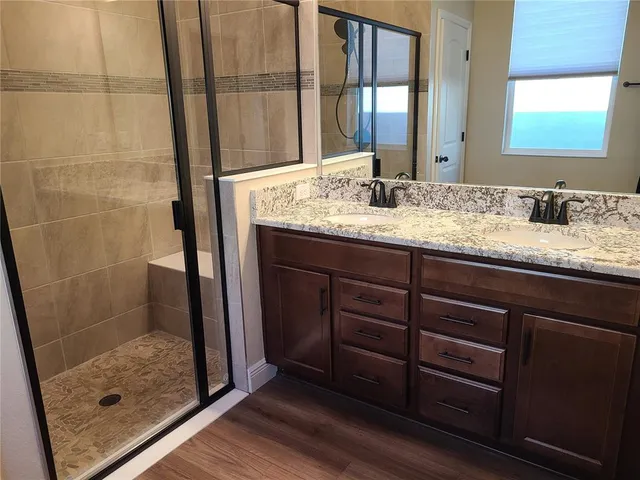 a bathroom with a granite countertop sink shower and mirror