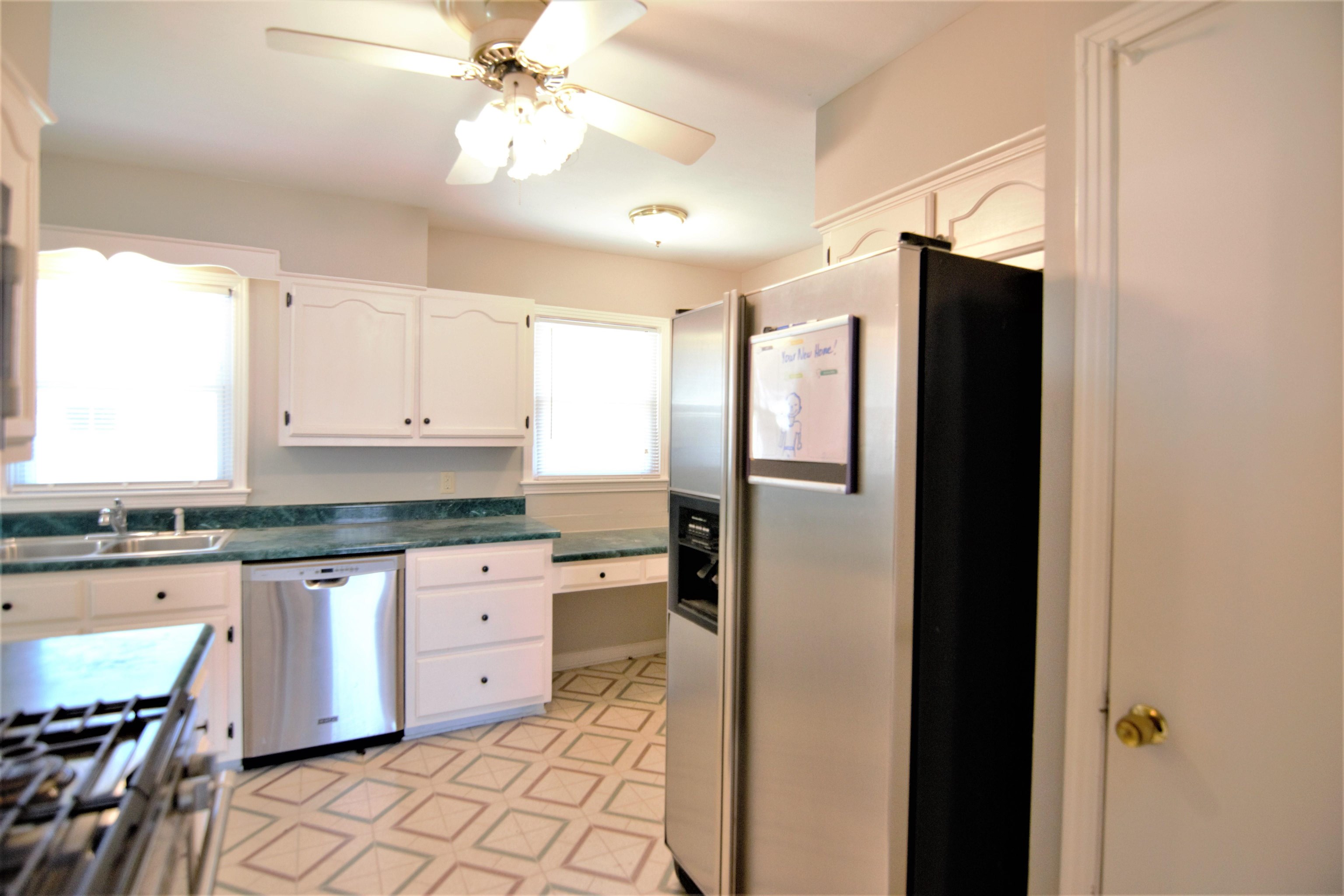 1596 Rabb Road Memphis, TN 38119 - Photo 9 of 20 a kitchen with granite countertop a refrigerator a sink a stove and white cabinets