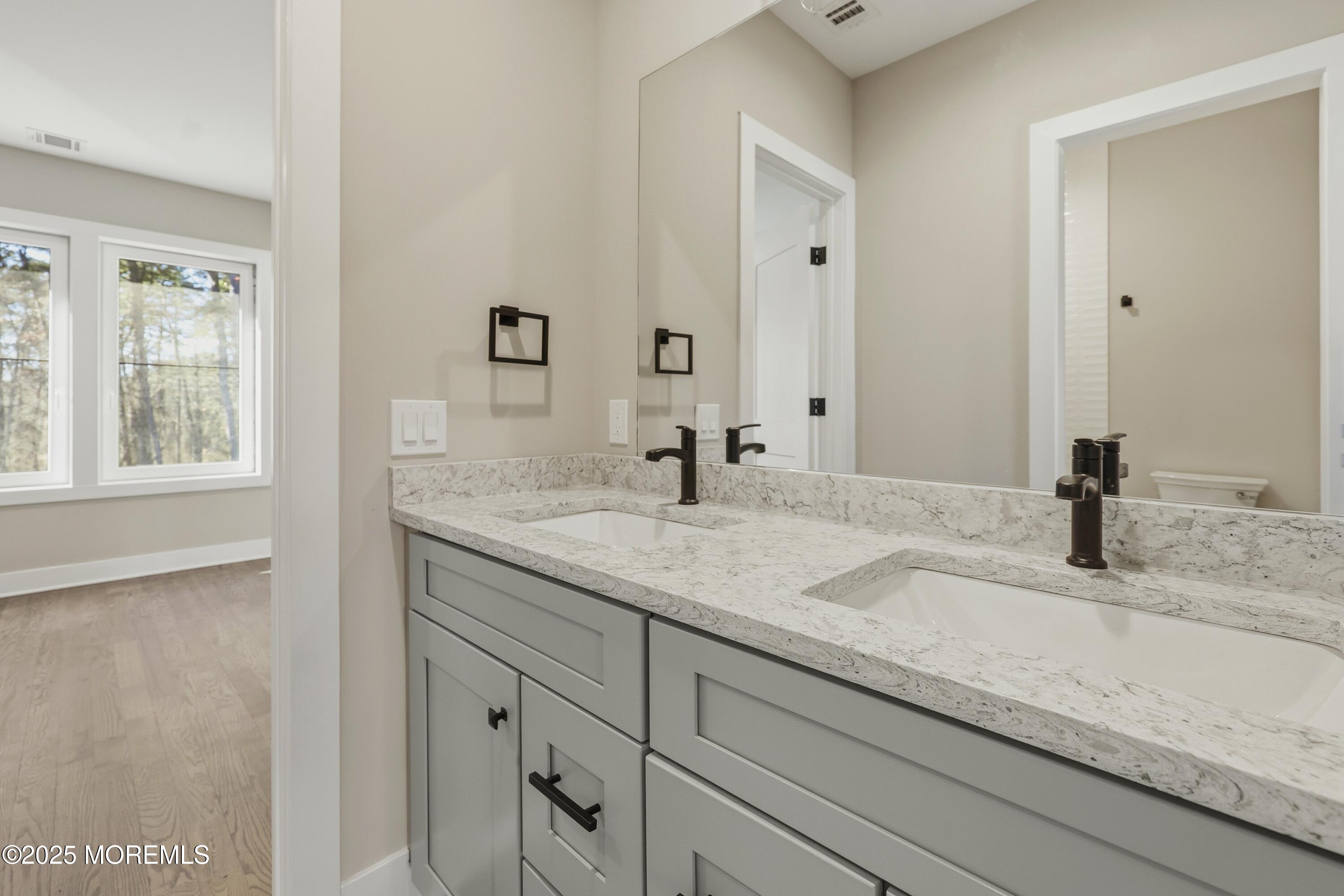2 Haystack Court Howell, NJ 07731 - Photo 38 of 78 a bathroom with a granite countertop sink and a mirror