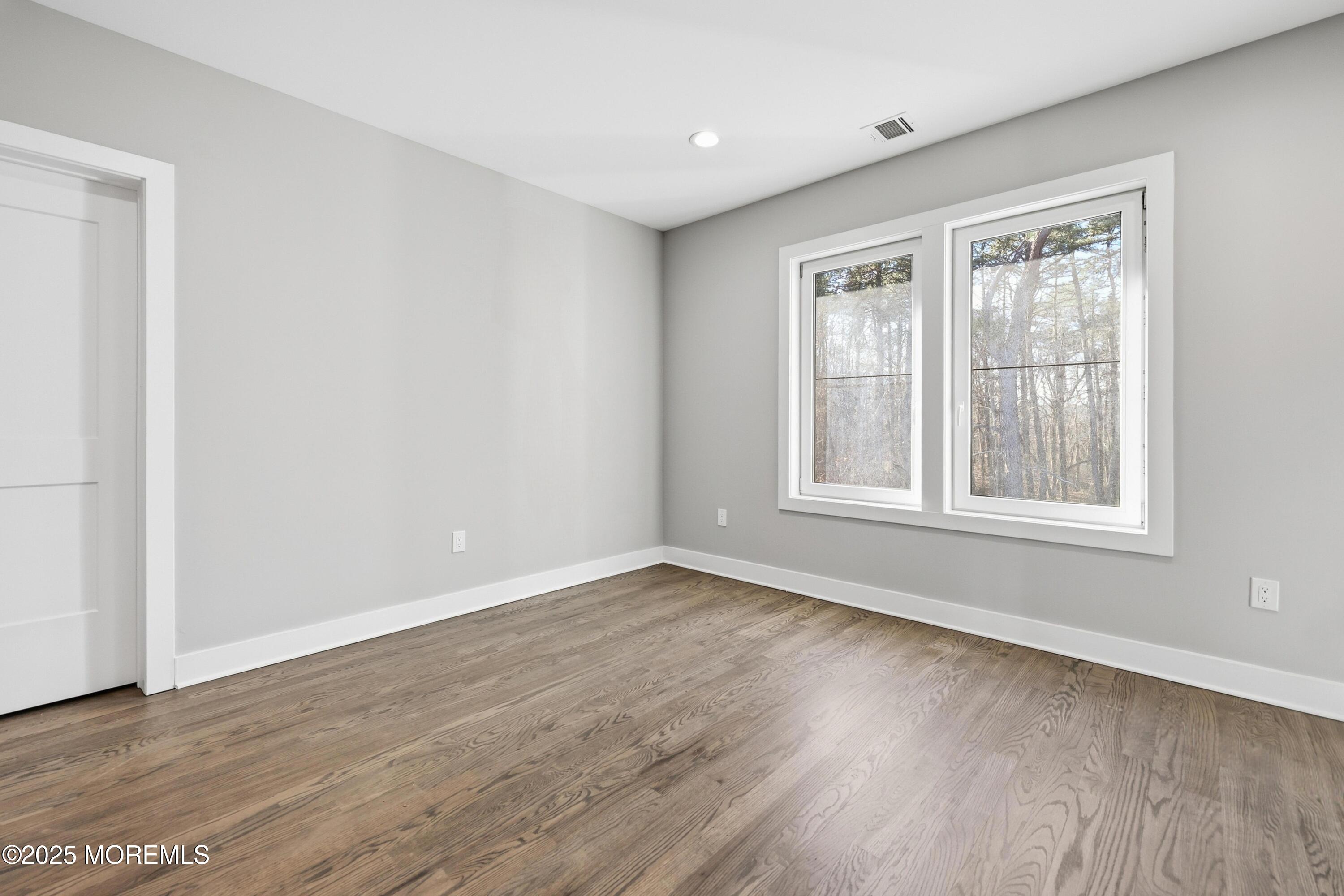 2 Haystack Court Howell, NJ 07731 - Photo 58 of 78 a view of an empty room with wooden floor and a window