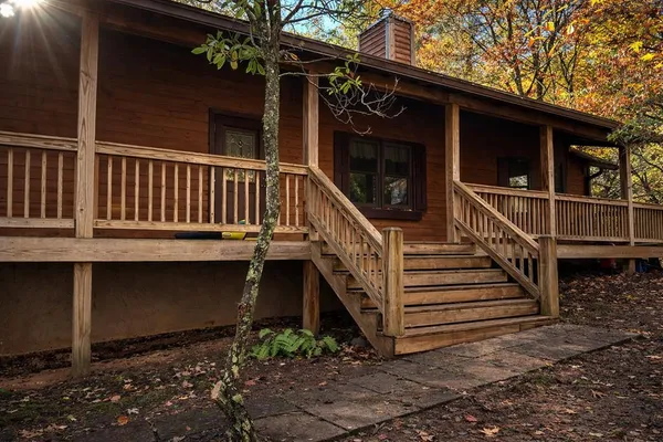 a view of wooden house with a small yard