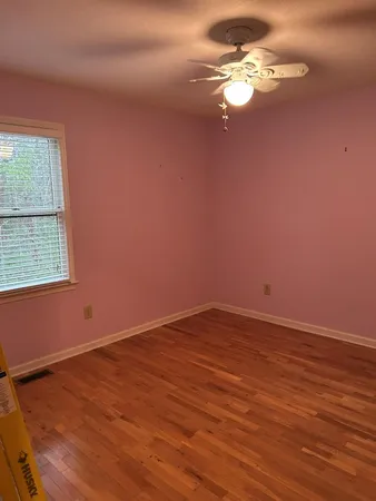 a view of a room with wooden floor and a ceiling fan