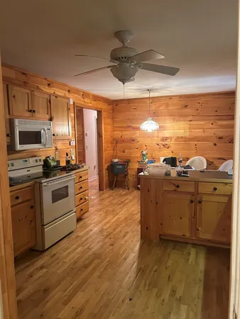 a kitchen with stainless steel appliances kitchen island granite countertop a stove a sink and white cabinets
