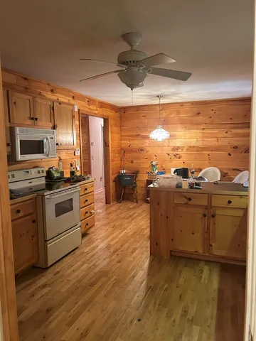 a kitchen with stainless steel appliances kitchen island granite countertop a stove a sink and white cabinets