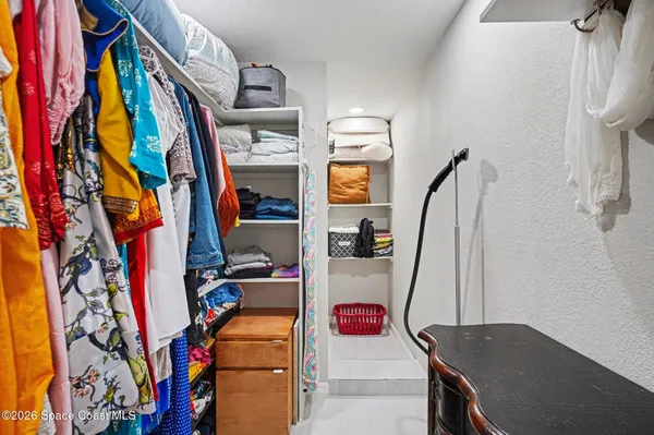 a view of walk in closet with clothes and shoes