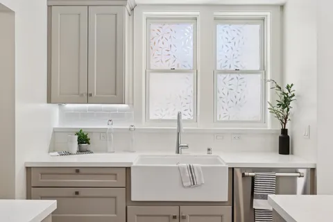 a kitchen with a refrigerator sink and white cabinets