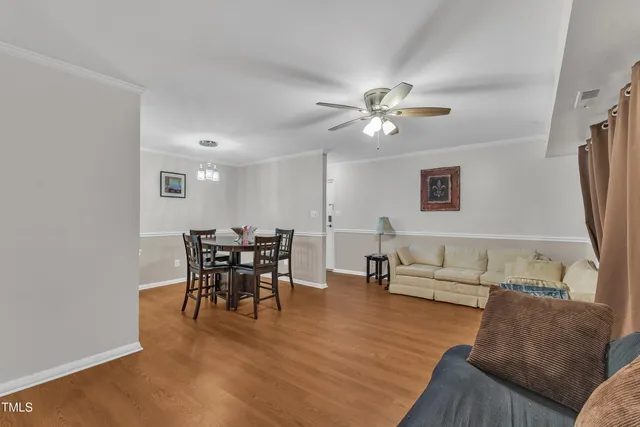 a living room with furniture a dining table and a chandelier