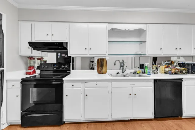 a kitchen with white cabinets and appliances