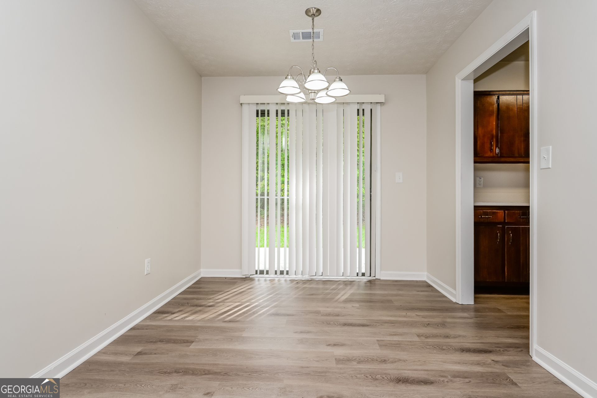 2140 Teri Lane Southeast Conyers, GA 30013 - Photo 4 of 16 a view of an empty room with wooden floor and a window