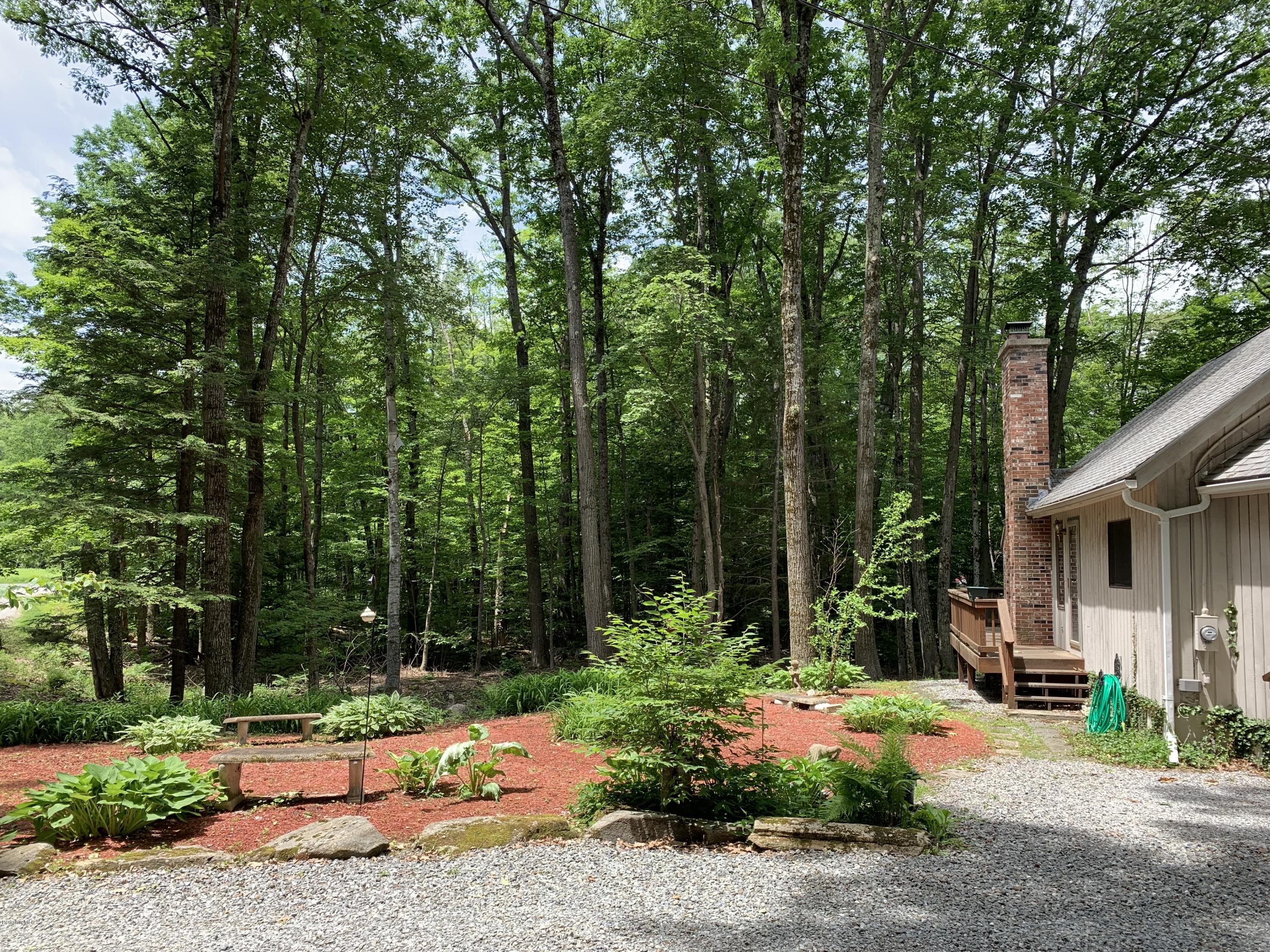 29 Pinnacle Road Otis, MA 01253 - Photo 34 of 37 a backyard of a house with table and chairs plants and large trees