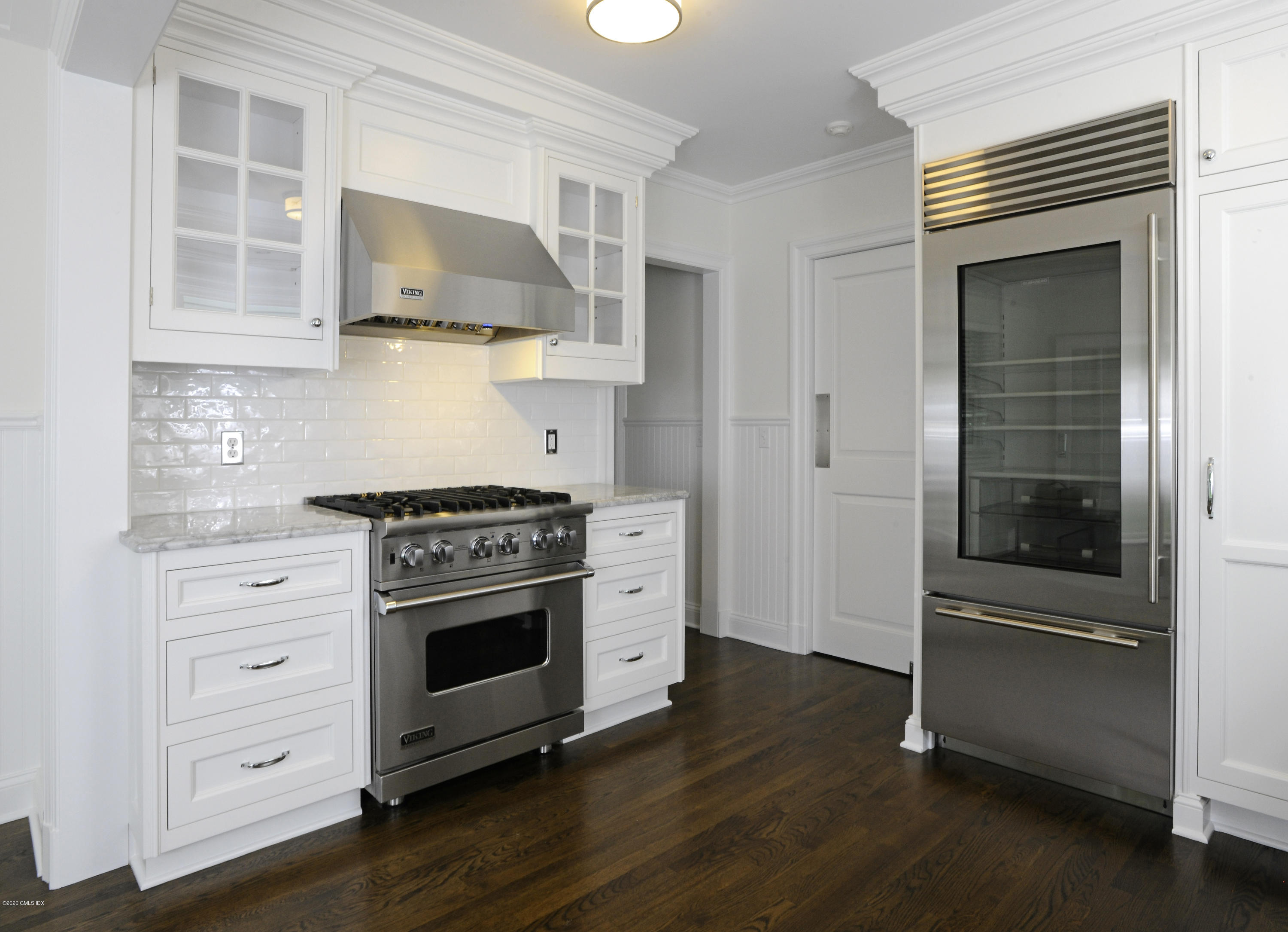 13 Grigg Street Greenwich, CT 06830 - Photo 25 of 30 a kitchen with stainless steel appliances white cabinets and a wooden floor