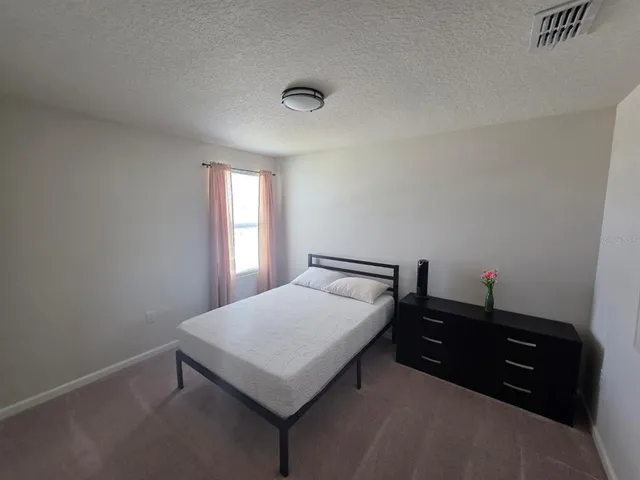 a bedroom with a bed and window