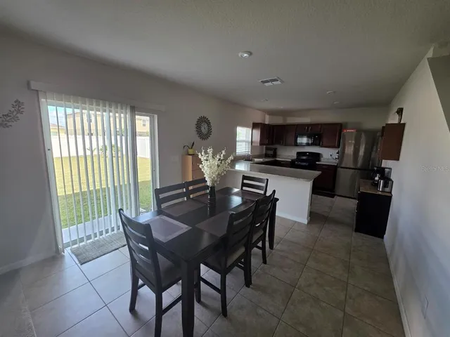 a view of a dining room with furniture and a kitchen