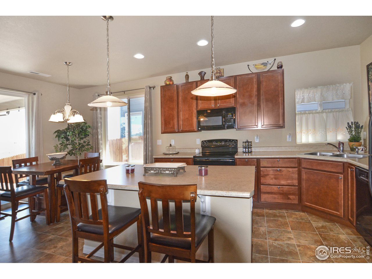 2045 Reed Grass Way Colorado Springs, CO 80915 - Photo 12 of 33 a kitchen with stainless steel appliances a stove a table and chairs