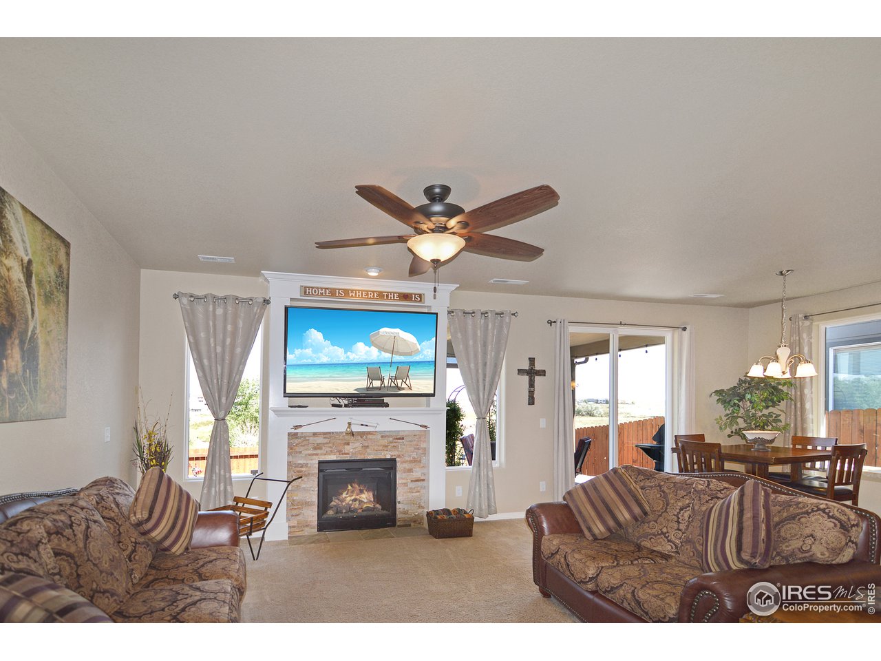 2045 Reed Grass Way Colorado Springs, CO 80915 - Photo 5 of 33 a living room with furniture a fireplace and a flat screen tv