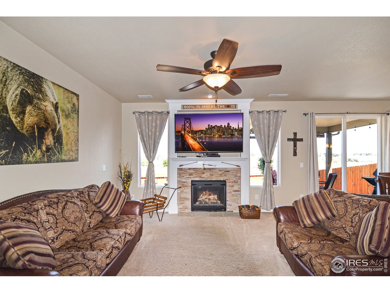 2045 Reed Grass Way Colorado Springs, CO 80915 - Photo 6 of 33 a living room with furniture a fireplace and a flat screen tv