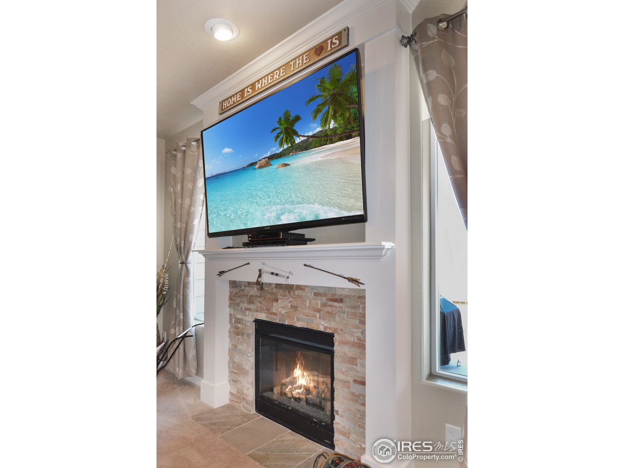 2045 Reed Grass Way Colorado Springs, CO 80915 - Photo 7 of 33 a living room with a fireplace and a flat screen tv