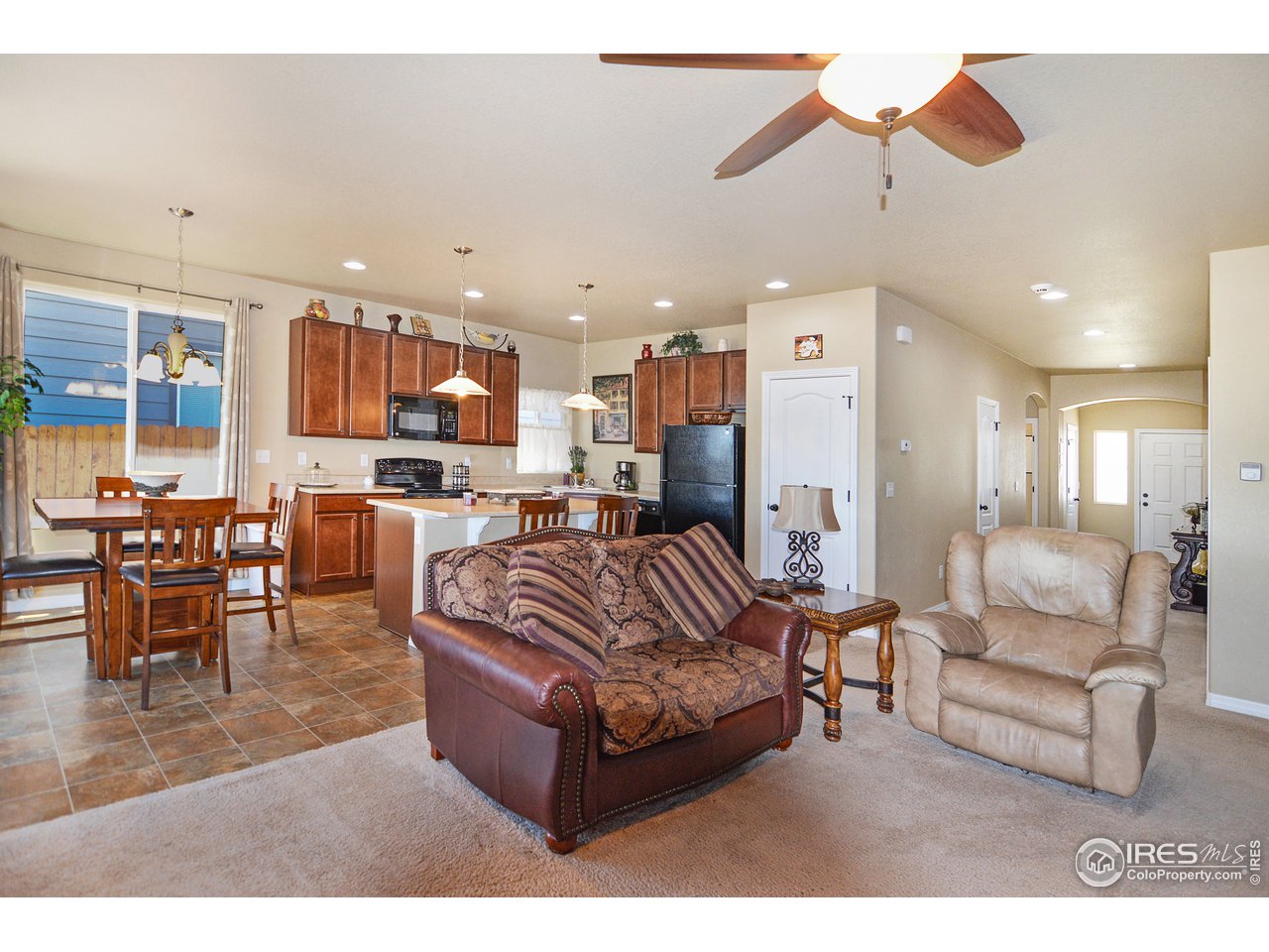 2045 Reed Grass Way Colorado Springs, CO 80915 - Photo 8 of 33 a living room with furniture and a dining table with kitchen view