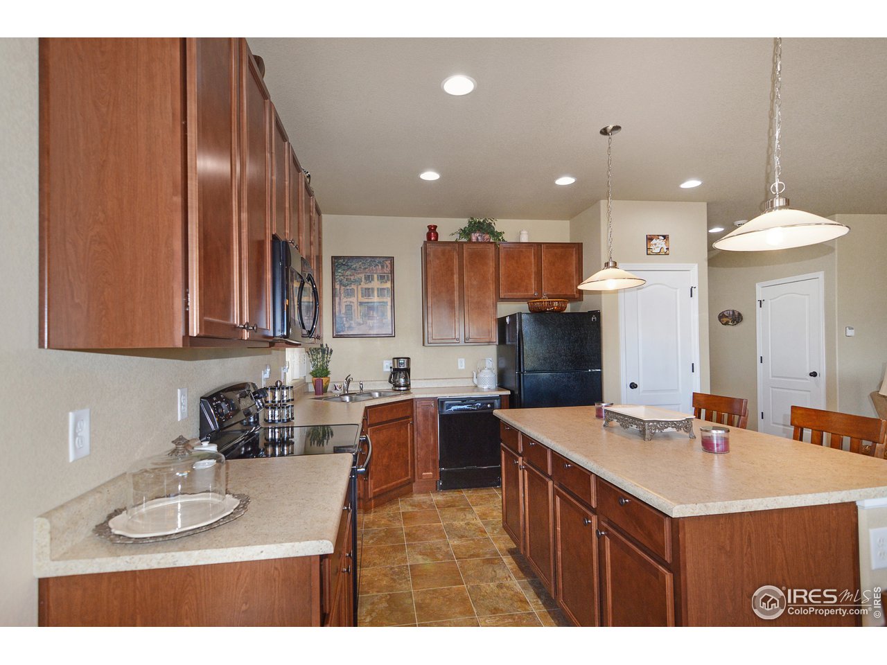 2045 Reed Grass Way Colorado Springs, CO 80915 - Photo 10 of 33 a kitchen with stainless steel appliances granite countertop a sink stove and refrigerator
