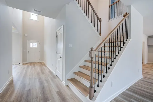 a view of staircase with wooden floor and white walls