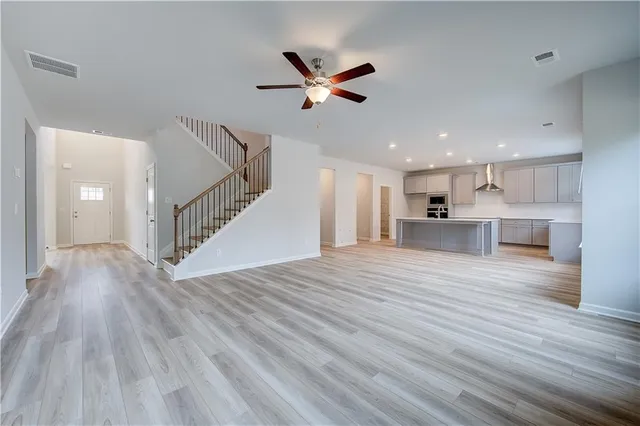a view of empty room with wooden floor and ceiling fan