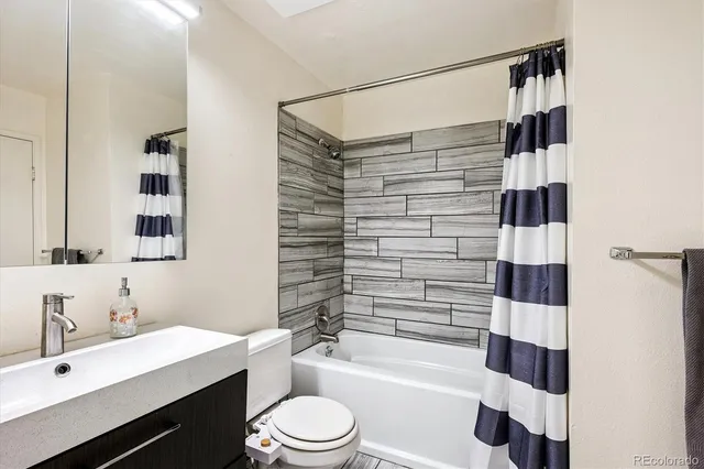 a bathroom with a sink a toilet a shower and a mirror