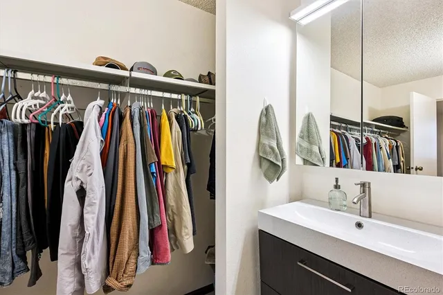 a view of walk in closet with clothes and shoes