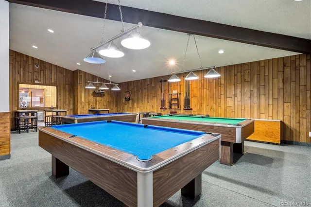 a room with pool table and windows