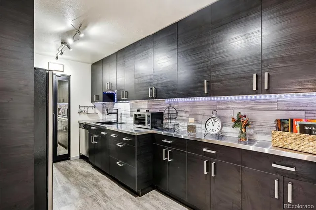 a kitchen with stainless steel appliances granite countertop a sink a stove and refrigerator