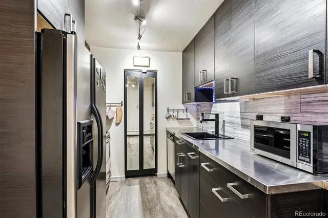 a kitchen with stainless steel appliances a sink stove and refrigerator