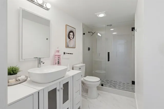 a bathroom with a sink a toilet and shower