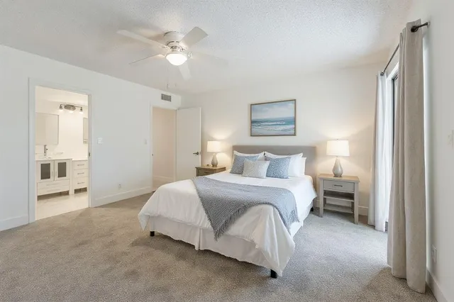 a spacious bedroom with a bed and a ceiling fan