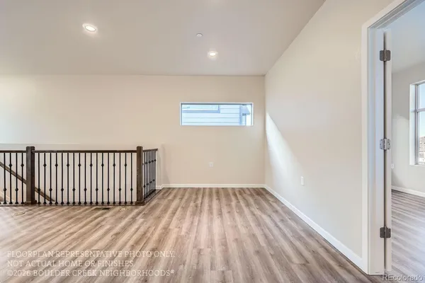 a view of a hallway with wooden floor and a window