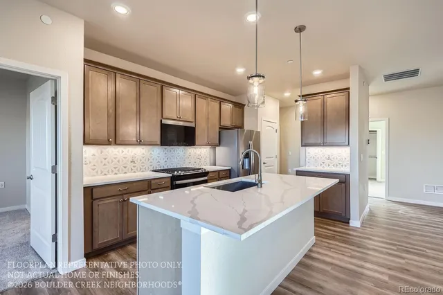 a kitchen with a sink a counter top space stainless steel appliances and cabinets