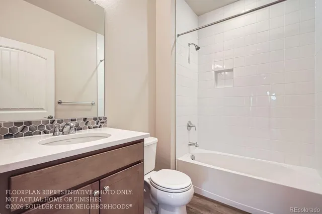 a bathroom with a sink a toilet a mirror and shower