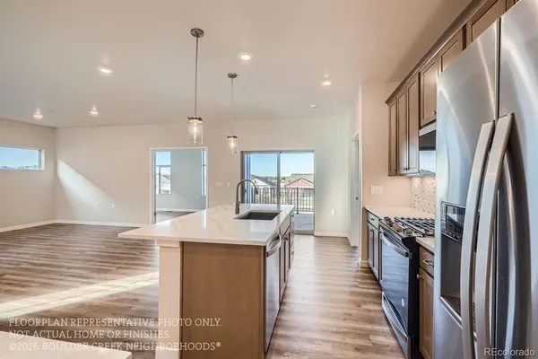 a kitchen with stainless steel appliances granite countertop a refrigerator a oven and a sink with wooden floor