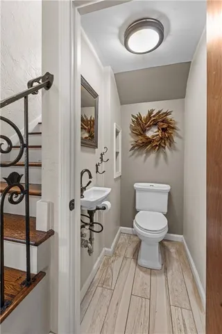 a bathroom with a toilet a sink and mirror