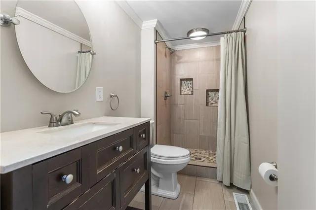 a bathroom with a double vanity sink toilet mirror and shower