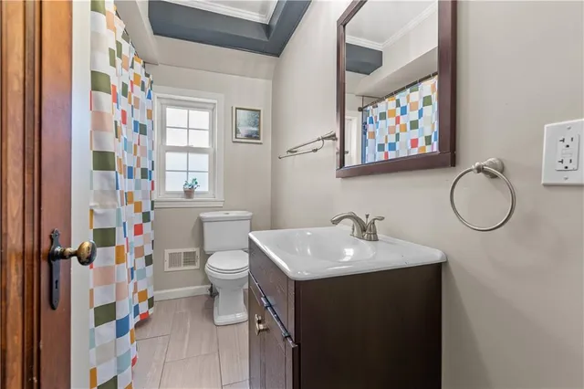 a bathroom with a sink vanity mirror and toilet