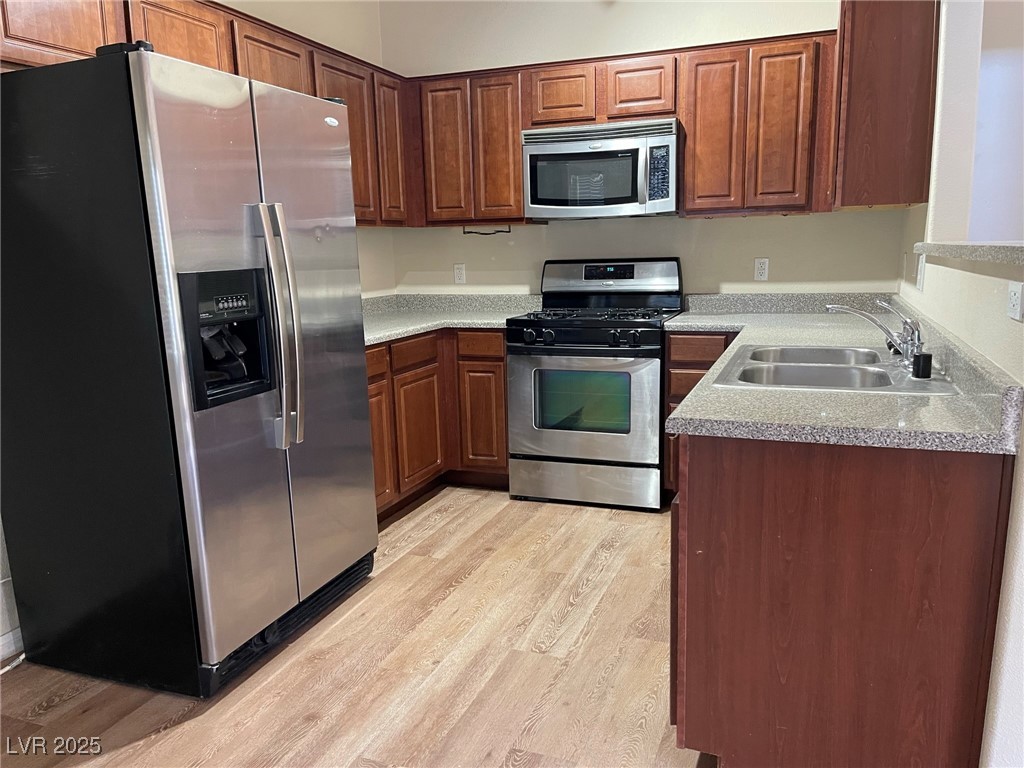10519 Hedge View Avenue Las Vegas, NV 89129 - Photo 9 of 39 Kitchen with light wood finished floors, a sink, s