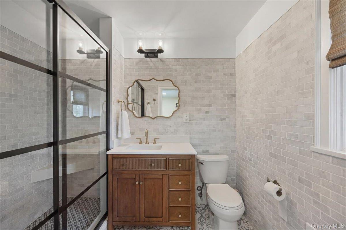 311 Lyncroft Road New Rochelle, NY 10804 - Photo 23 of 39 a bathroom with a toilet a sink and mirror