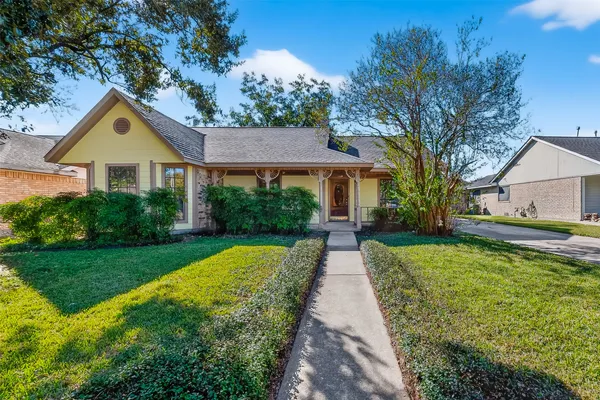 a front view of a house with a yard and trees