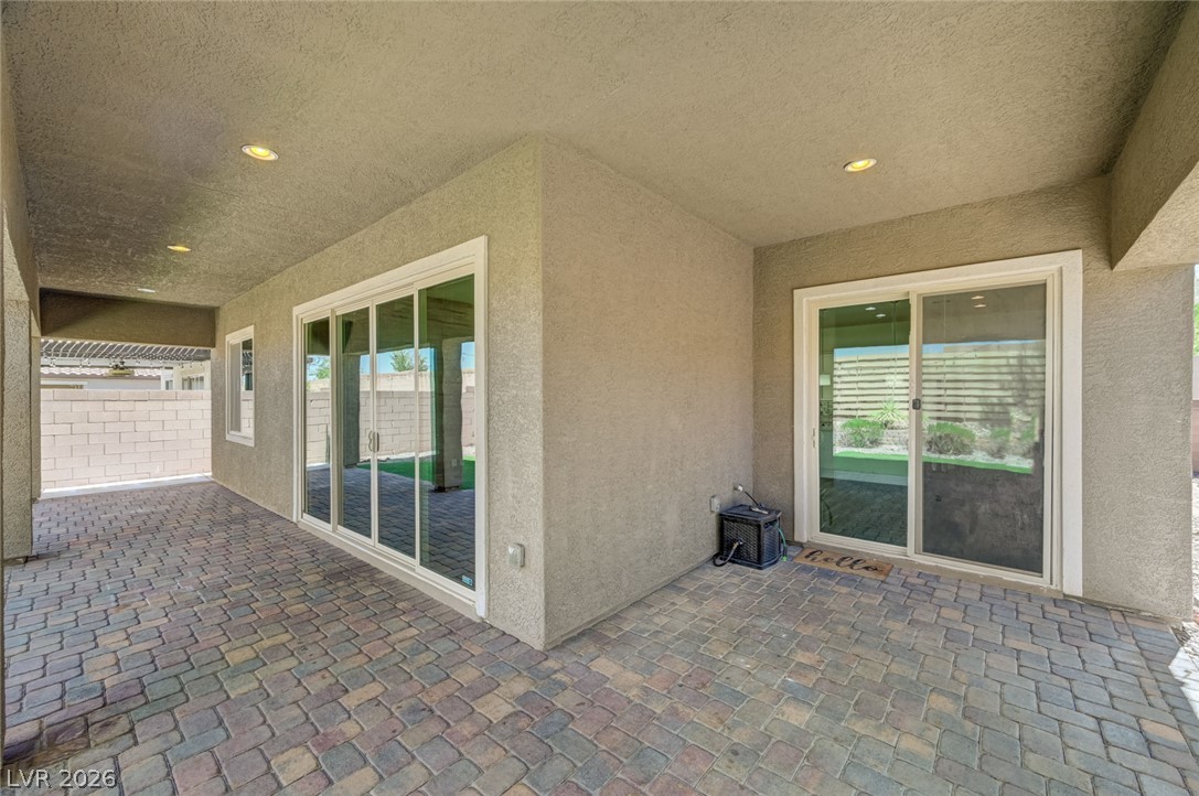 8197 Riley Love Street Las Vegas, NV 89139 - Photo 38 of 48 A spacious covered patio with paver flooring offers a seamless indoor-outdoor transition through multiple sliding glass doors.