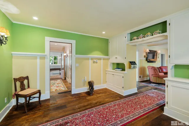 a view of a patio with table and chairs and potted plants and large trees