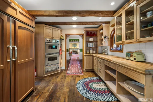 a view of a yard with plants and large trees